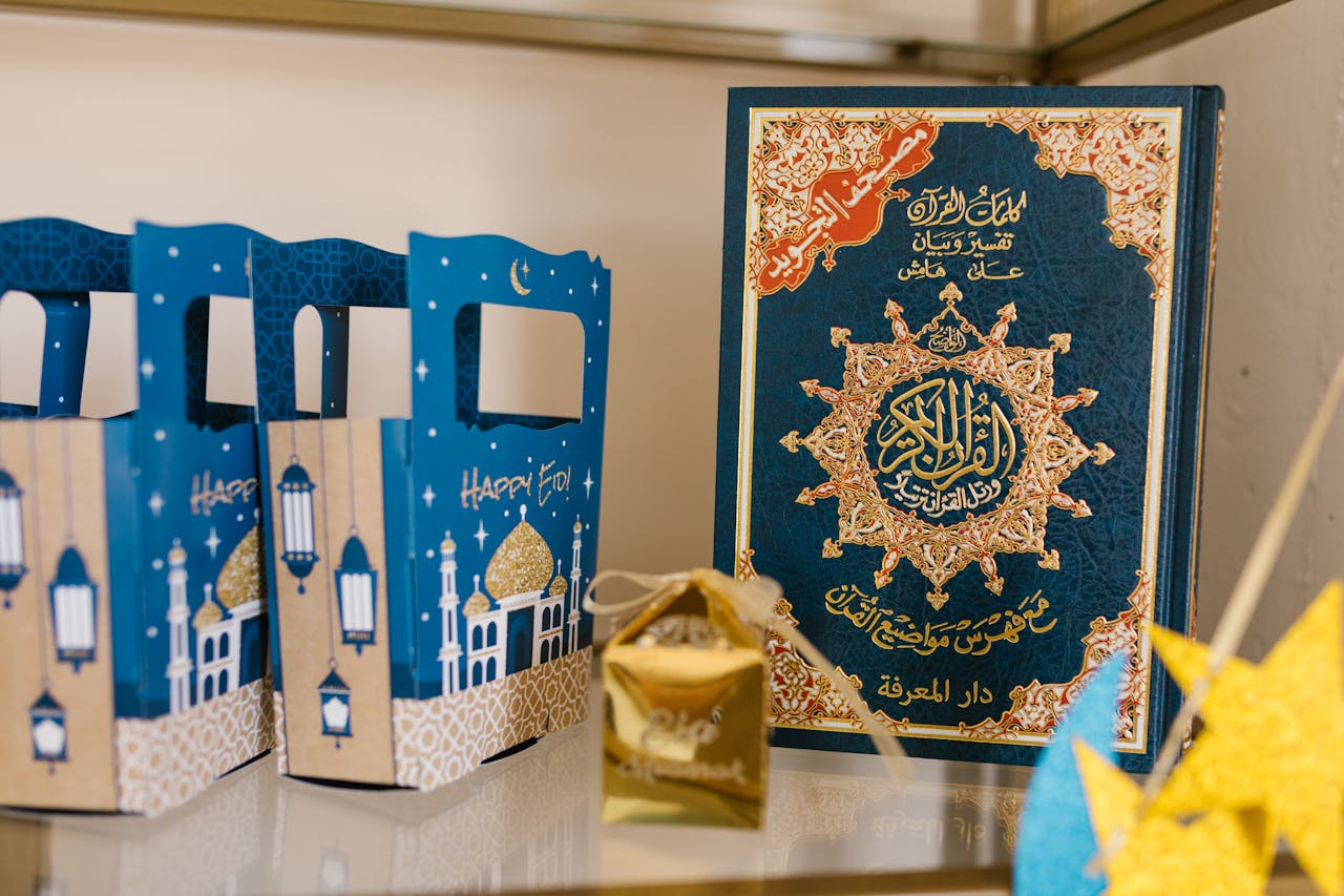 A decorated Quran and Eid-themed gift boxes signify the celebration of Eid, reflecting a festive atmosphere.